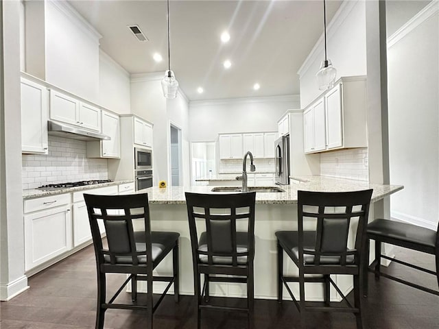 kitchen with white cabinetry, decorative light fixtures, a breakfast bar, and stainless steel appliances