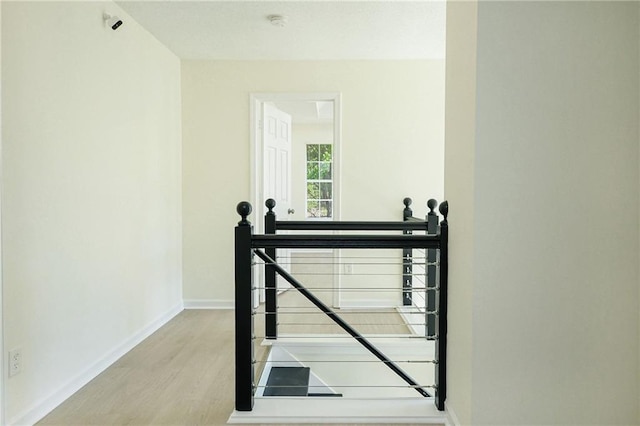 stairway with wood finished floors and baseboards