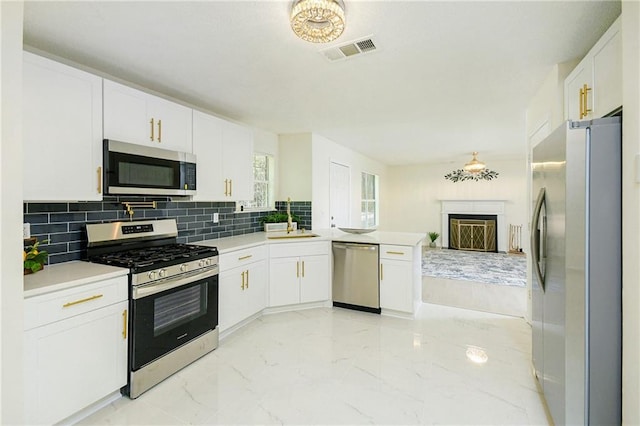 kitchen featuring light countertops, decorative backsplash, white cabinetry, and stainless steel appliances