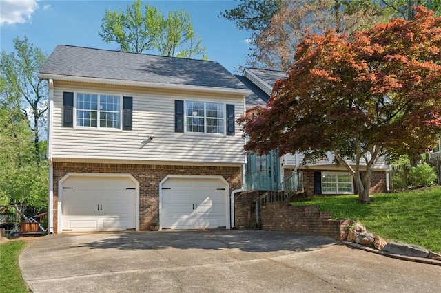 view of front of property with brick siding, an attached garage, driveway, and a front lawn