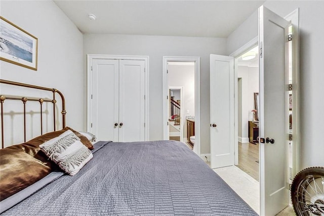 bedroom featuring connected bathroom, a closet, and light wood-type flooring