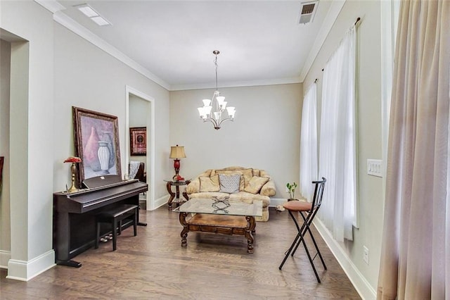 sitting room with ornamental molding, a chandelier, and dark wood-type flooring