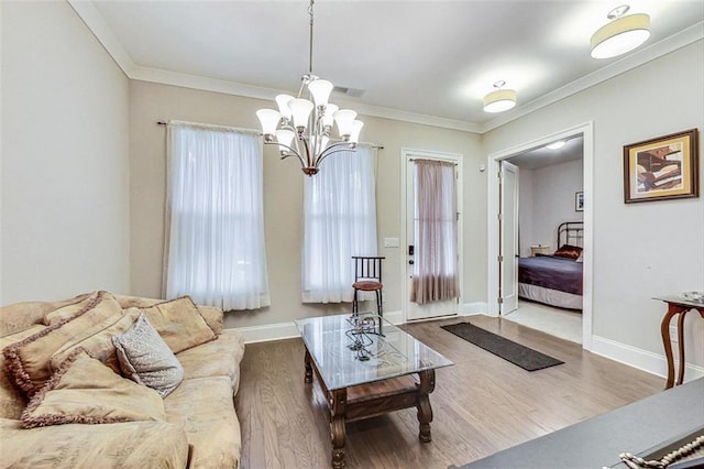 living room featuring ornamental molding, an inviting chandelier, and hardwood / wood-style floors