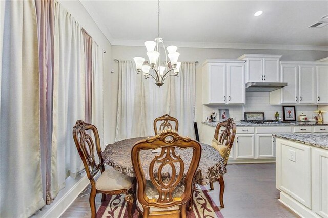 dining space featuring ornamental molding, dark hardwood / wood-style floors, and a chandelier