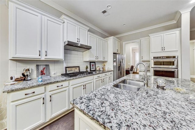 kitchen featuring appliances with stainless steel finishes, light stone countertops, sink, and white cabinets