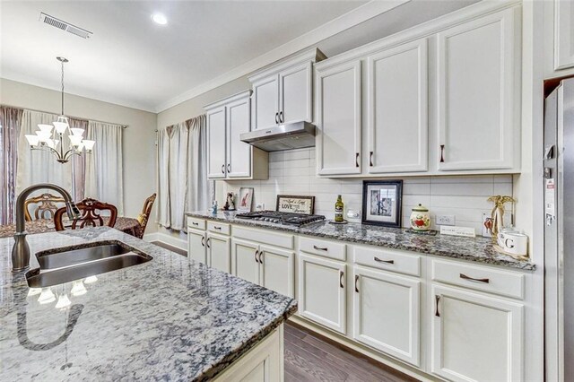 kitchen featuring white cabinets, stainless steel gas stovetop, dark hardwood / wood-style floors, a chandelier, and sink