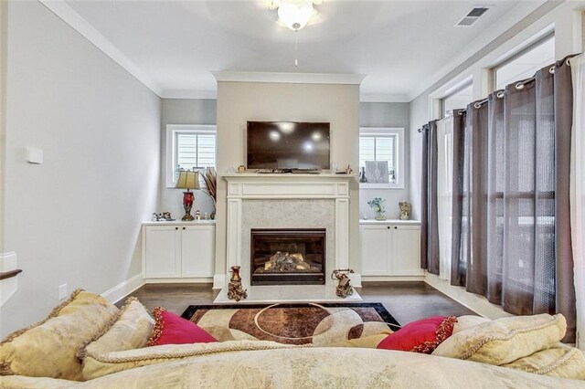 living room featuring crown molding, dark hardwood / wood-style floors, a high end fireplace, and a wealth of natural light