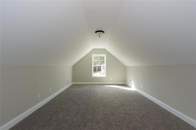 additional living space featuring vaulted ceiling and carpet