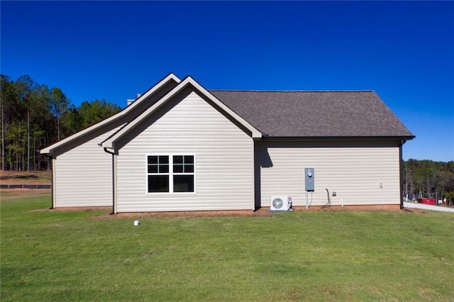 back of property featuring a lawn and ac unit