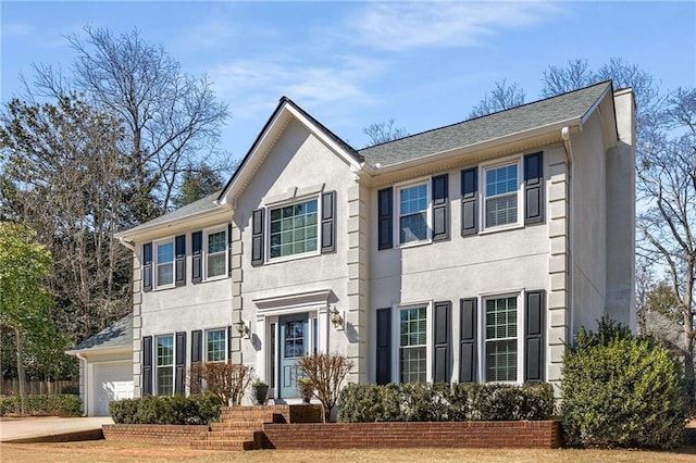 view of front facade with a garage and stucco siding