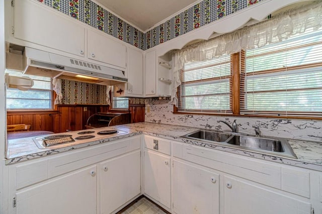 kitchen with light countertops, white cabinetry, a sink, white cooktop, and under cabinet range hood