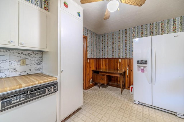 kitchen with wallpapered walls, white appliances, wainscoting, and white cabinets