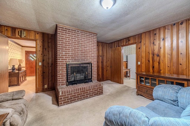 living area with wooden walls, light carpet, a fireplace, and a textured ceiling