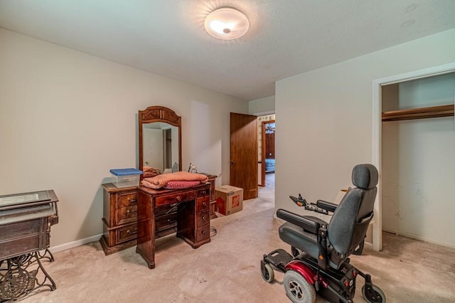 office area featuring light carpet and baseboards