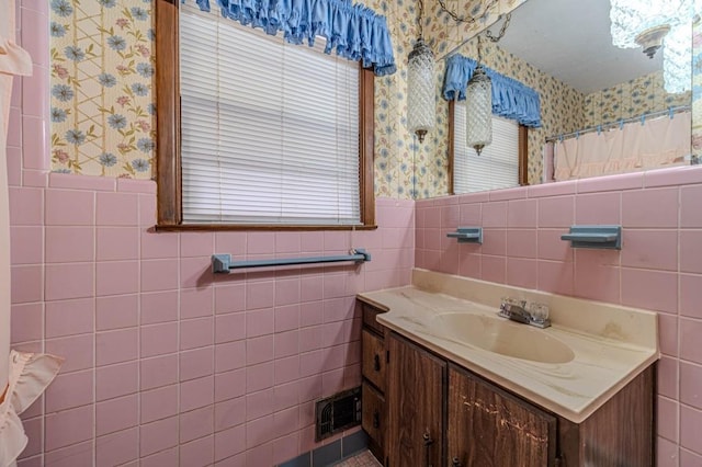 bathroom featuring wainscoting, visible vents, and wallpapered walls