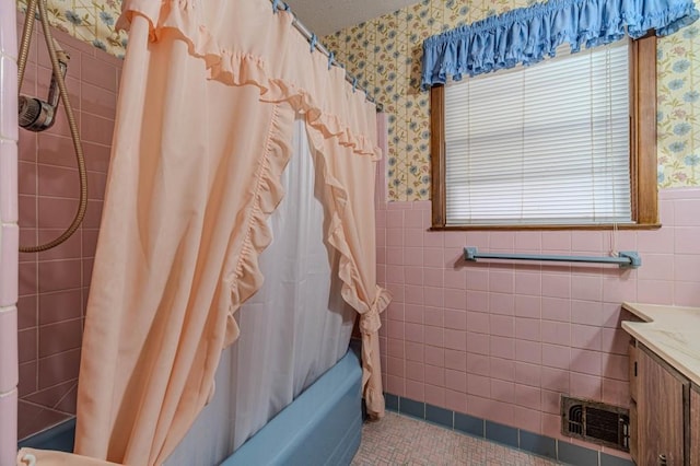 full bath featuring wallpapered walls, visible vents, and a wainscoted wall