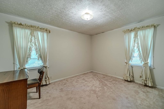 office space featuring light carpet, a textured ceiling, and baseboards