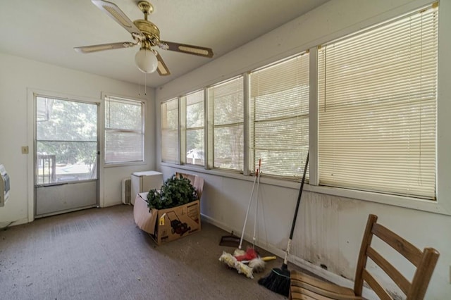 unfurnished sunroom featuring ceiling fan