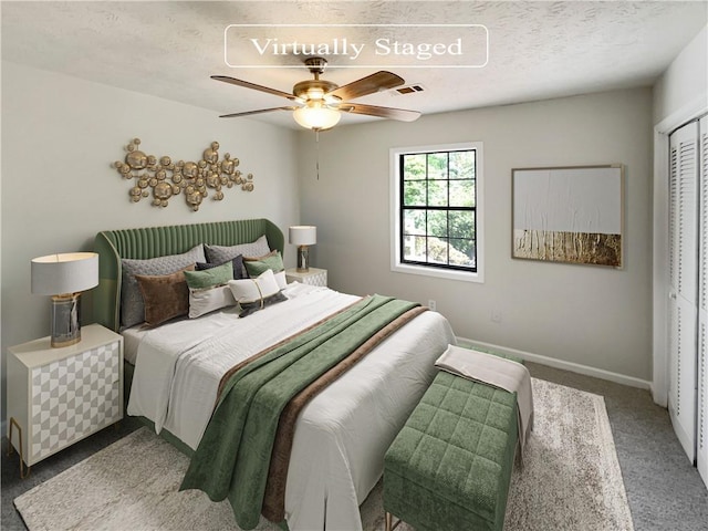 bedroom with a textured ceiling, carpet floors, a closet, and ceiling fan