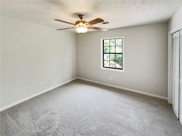 unfurnished bedroom featuring ceiling fan, a closet, carpet, and a textured ceiling