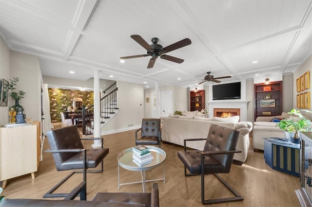 living room with coffered ceiling, light hardwood / wood-style flooring, and ornate columns