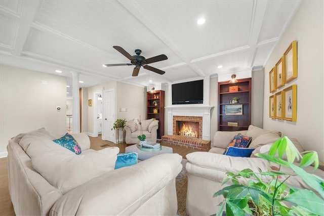 living room featuring coffered ceiling, a fireplace, and ceiling fan