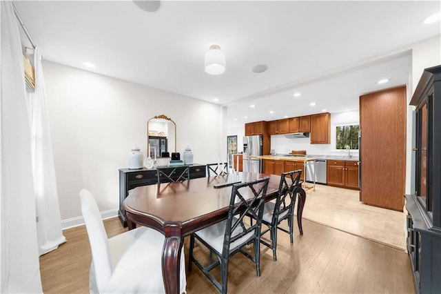 dining space with sink and light hardwood / wood-style flooring