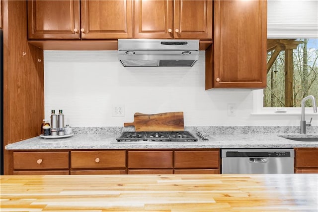 kitchen featuring butcher block countertops, ventilation hood, stainless steel appliances, and sink