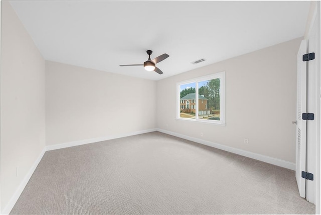 carpeted spare room featuring ceiling fan