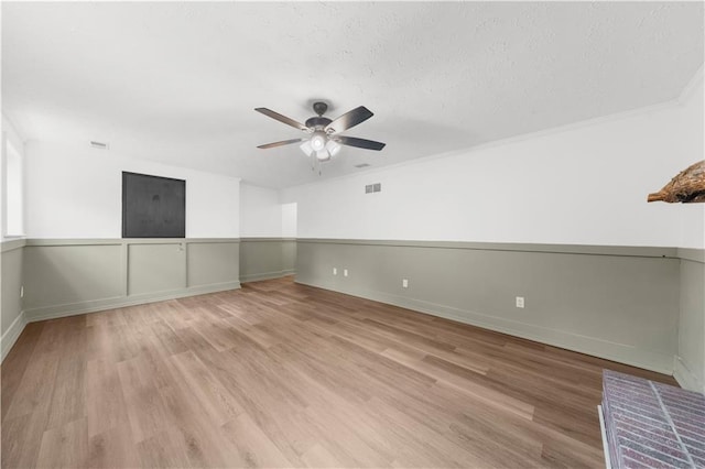 unfurnished room featuring ceiling fan, a textured ceiling, and light wood-type flooring