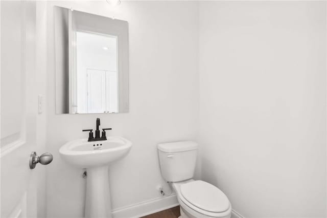 bathroom with hardwood / wood-style floors, toilet, and sink