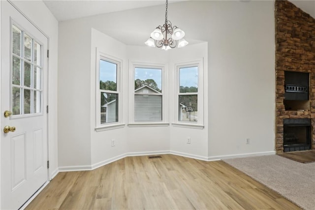 foyer featuring a chandelier, visible vents, light wood-style floors, and vaulted ceiling