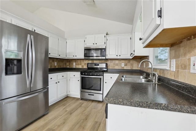 kitchen with a sink, lofted ceiling, tasteful backsplash, and stainless steel appliances