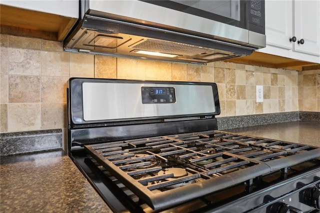 details featuring dark countertops, white cabinets, backsplash, and appliances with stainless steel finishes