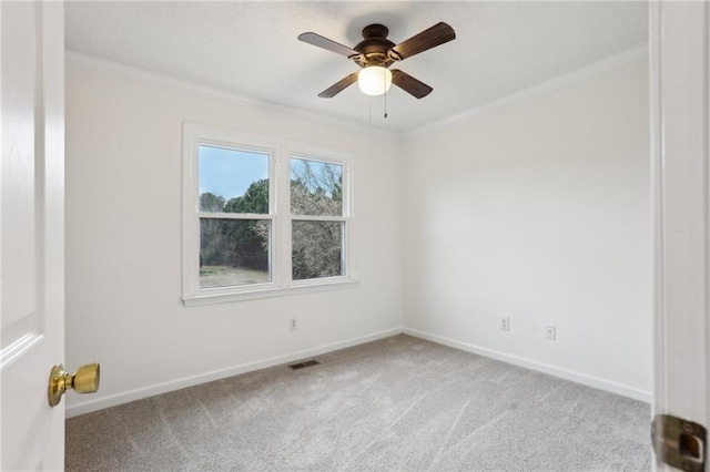 carpeted spare room featuring visible vents, crown molding, and baseboards