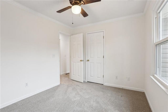 unfurnished bedroom featuring multiple windows, carpet floors, and crown molding