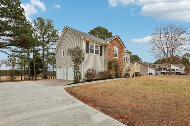 view of home's exterior with stairs, a yard, driveway, and an attached garage