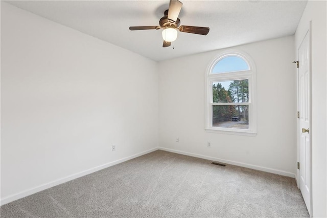 spare room featuring a ceiling fan, carpet, visible vents, and baseboards