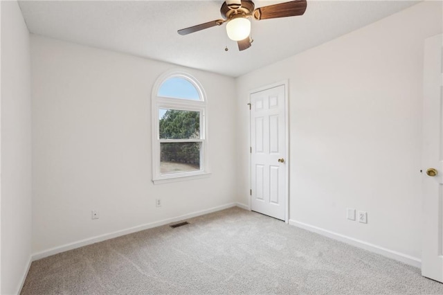 carpeted spare room featuring a ceiling fan, baseboards, and visible vents