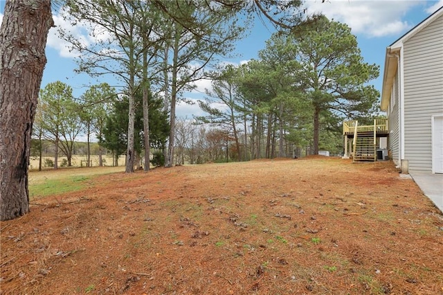 view of yard featuring a deck and stairs