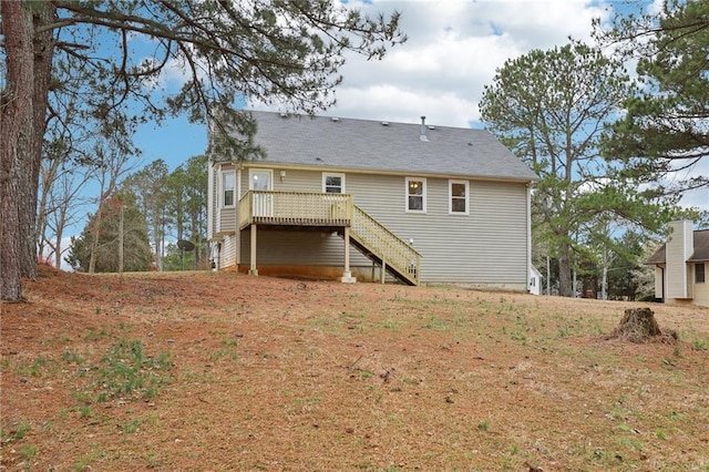 back of house featuring a lawn, a deck, and stairs