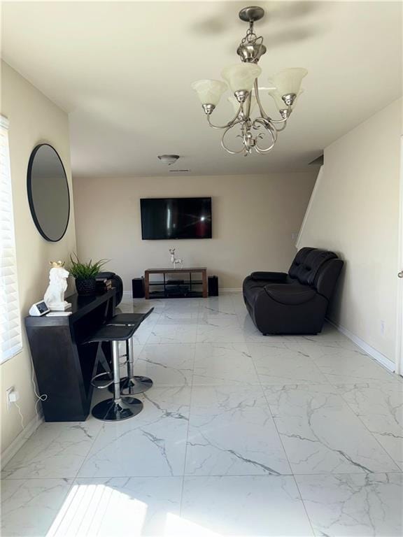 living room with marble finish floor, baseboards, and a notable chandelier