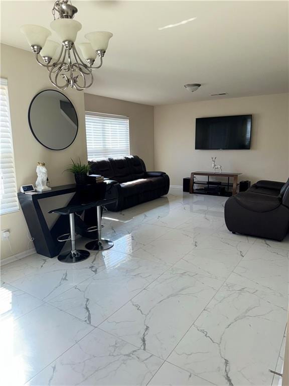 living area with marble finish floor, baseboards, and an inviting chandelier