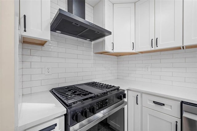 kitchen with white cabinets, decorative backsplash, high end stainless steel range, and wall chimney exhaust hood