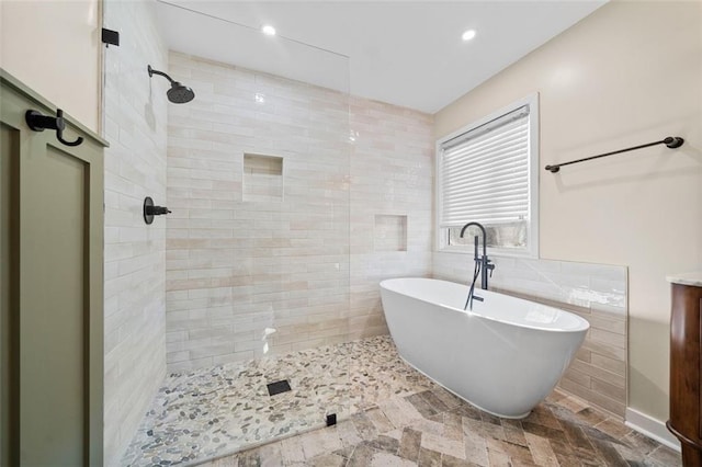 bathroom with tile walls and independent shower and bath