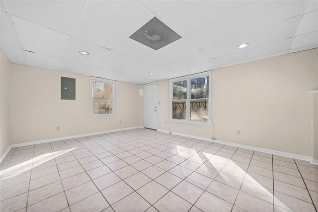 spare room featuring a paneled ceiling, light tile patterned floors, and electric panel