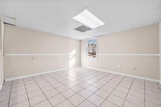 empty room featuring a drop ceiling and light tile patterned flooring