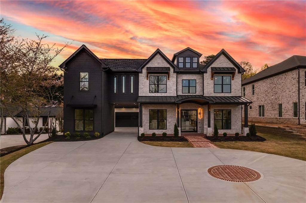 159 Shadburn Ferry Rd, Buford, GA 30518 - view of front of property with curved driveway, a standing seam roof, metal roof, a front lawn, and a garage