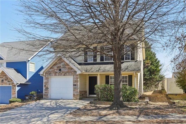 view of front of house featuring an attached garage, driveway, and stone siding