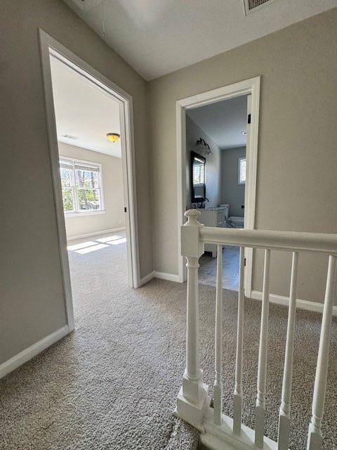 hallway featuring baseboards and carpet